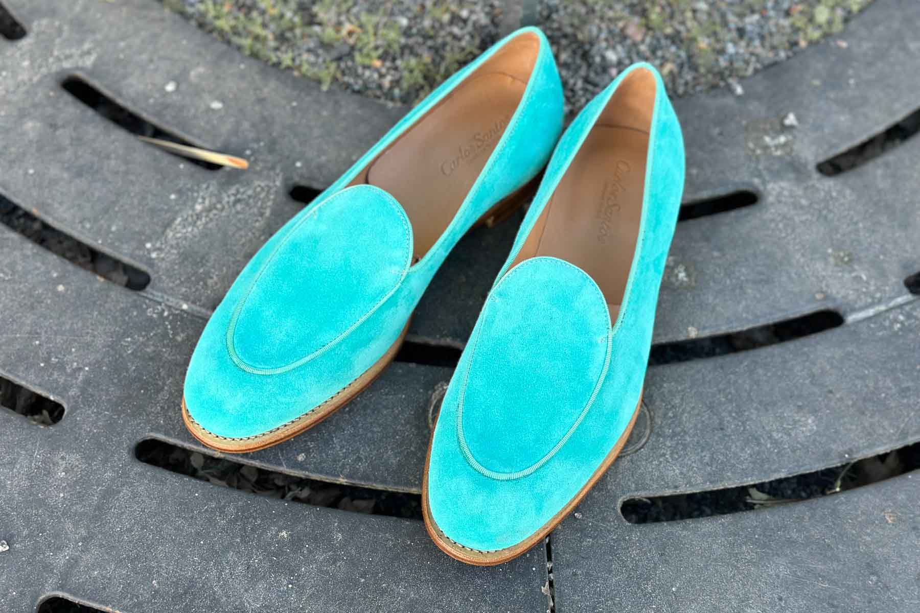 Carlos Santos 1829 Belgian Loafers in turquoise suede with leather soles on an outdoor stone background