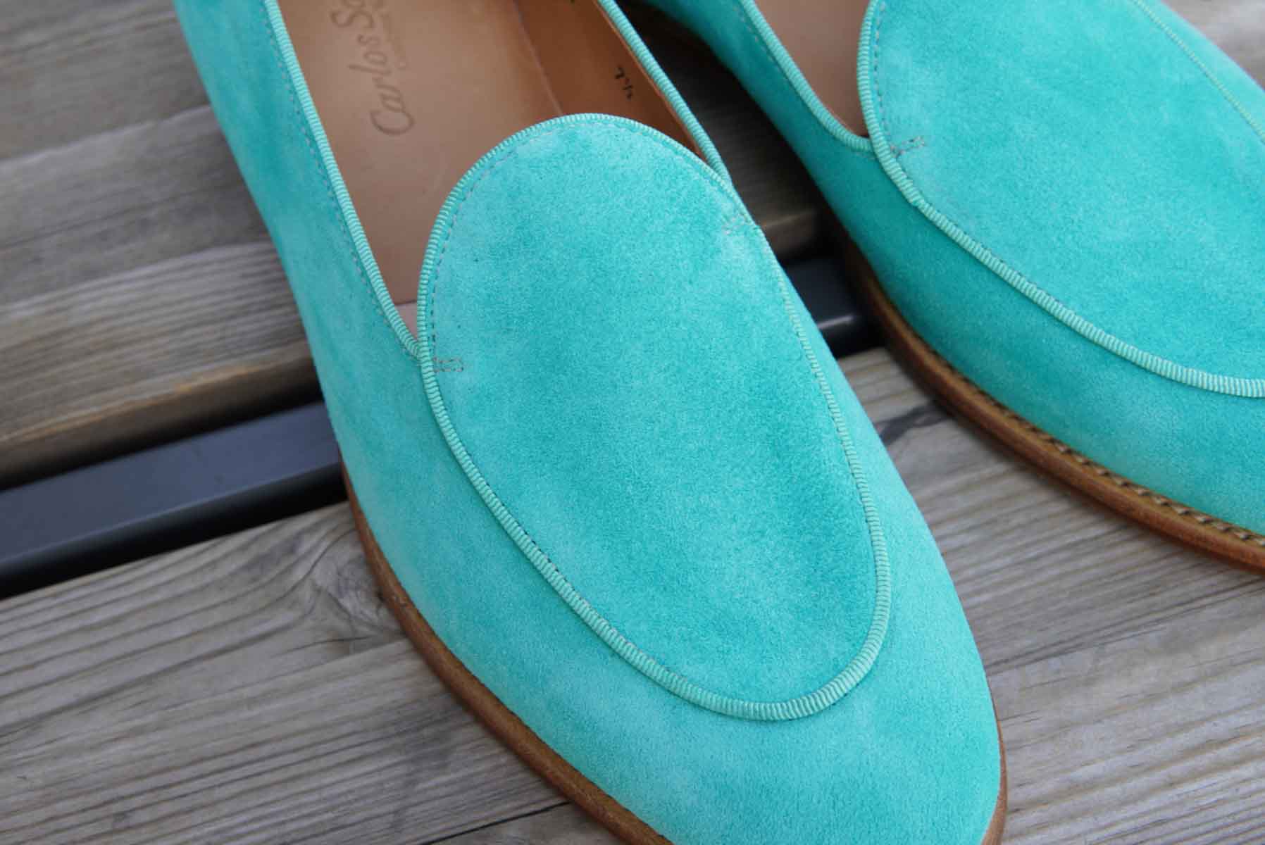 Carlos Santos 1829 Belgian Loafers in turquoise suede on a wooden surface.